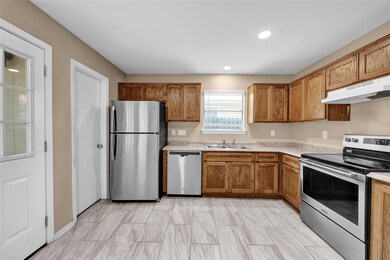Kitchen with light countertops, brown cabinets, s