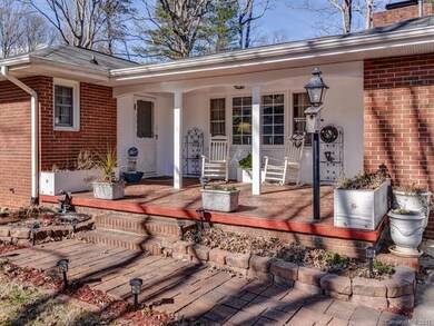Covered side porch overlooks level fenced yard and