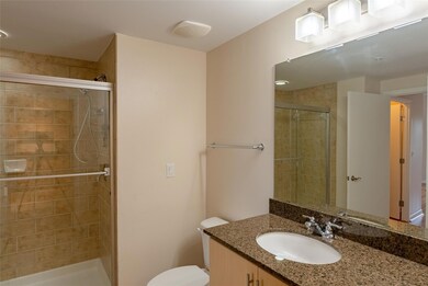 Bathroom featuring toilet, a stall shower, and va
