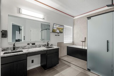 Bathroom featuring a bath, double vanity, walk in