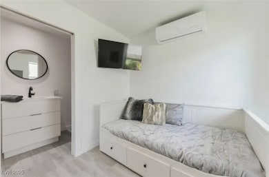 Bedroom featuring a wall mounted air conditioner a