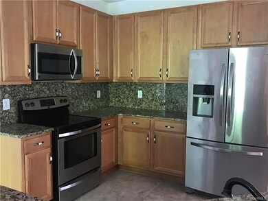 Kitchen features granite counters, tile floors, ss