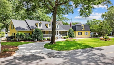 Cape cod-style house featuring a porch, a shingled