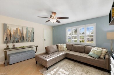 Living room featuring ceiling fan and light wood-t