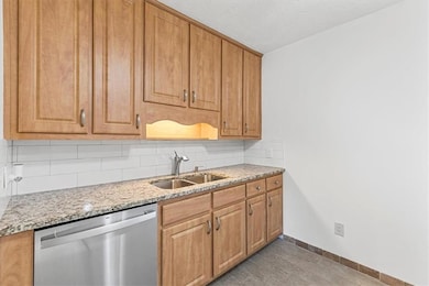 Kitchen with decorative backsplash, light stone co