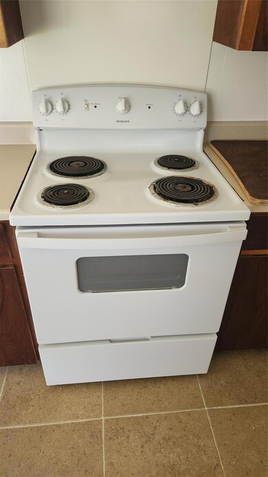 Kitchen featuring white range with electric stovetop and tile patterned flooring