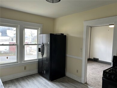 Kitchen with black appliances and light hardwood / wood-style flooring