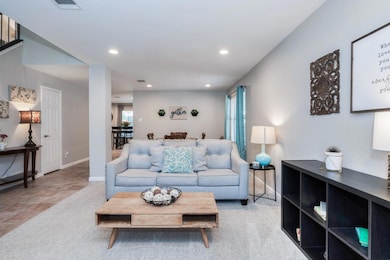 Carpeted living room with recessed lighting and baseboards