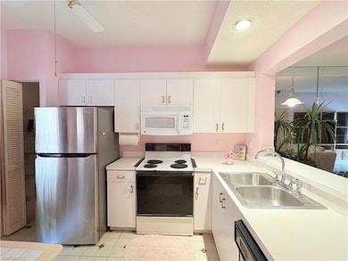 Kitchen featuring white appliances, a sink, white 