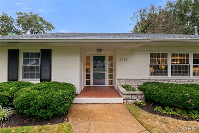 Doorway to property featuring brick siding and covered porch