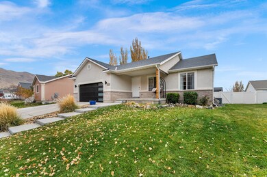 Ranch-style house featuring stucco siding, brick siding, covered porch, concrete driveway, and a garage