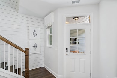 Foyer with dark wood-style floors, baseboards, and stairway