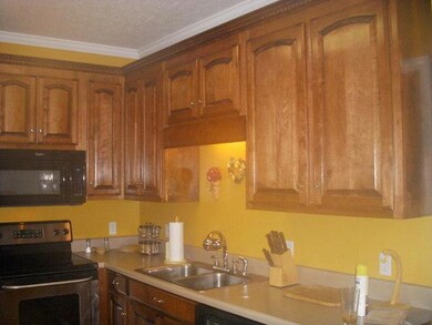 Large kitchen and breakfast nook with oak custom cabinets and oak flooring and stainless steel range and built in micro-wave makes this room the heart of the home