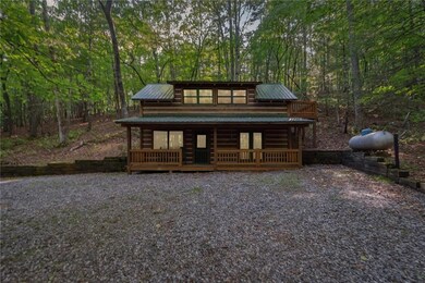 Cabin with metal roof, a forest view, and a wooden deck