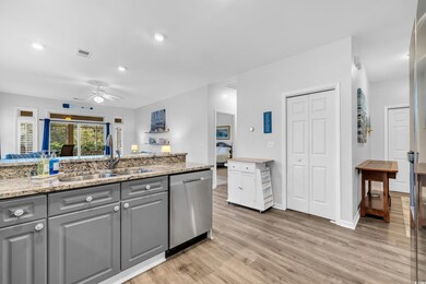 Kitchen with sink, gray cabinetry, light stone cou