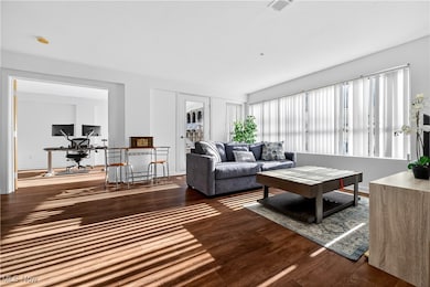 Living room featuring a desk and dark wood-style flooring