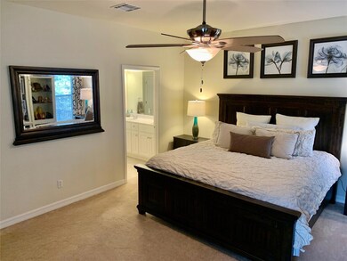 Bedroom with light carpet, connected bathroom, an