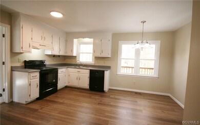 Kitchen with white cabinets, black appliances, a h