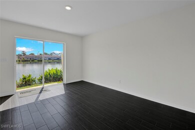 Empty room featuring a water view and dark hardwood / wood-style floors