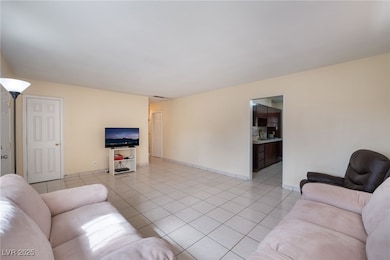 Living room with light tile patterned floors and baseboards