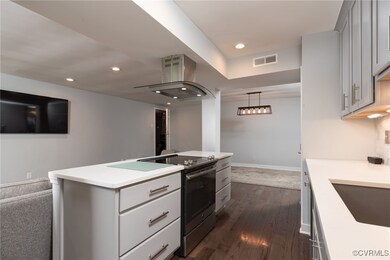 Kitchen featuring island range hood, electric rang