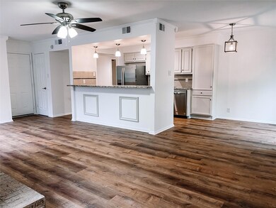 Kitchen featuring crown molding, tasteful backsplash, dark hardwood / wood-style flooring, ceiling fan, and stainless steel appliances