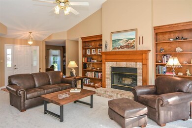 The great room has vaulted ceilings. The wood burning fireplace is flanked by beautiful built in shelving