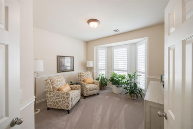 Sitting room featuring carpet flooring and baseboards