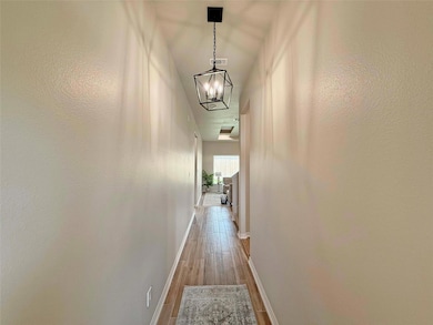 Hall featuring wood finished floors, a notable cha