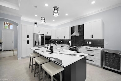 Kitchen featuring ornamental molding, a kitchen breakfast bar, white cabinetry, decorative backsplash, and beverage cooler