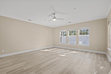 Spare room with crown molding, ceiling fan, and li