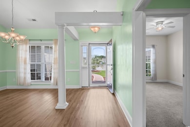 Entryway with baseboards, a chandelier, and healthy amount of natural light