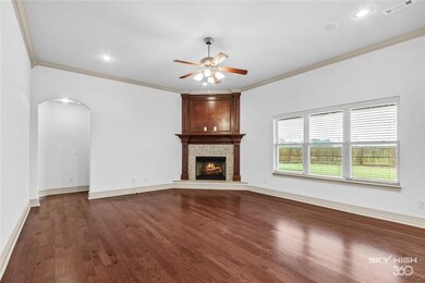 Living room features wood floors and a gas log fireplace.