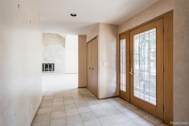 Foyer entrance featuring light tile patterned flooring, a tiled fireplace, and recessed lighting