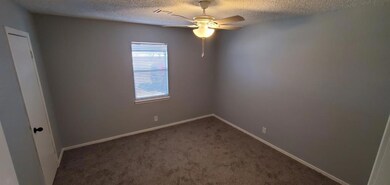 Carpeted spare room with a textured ceiling and ce