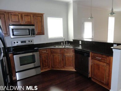 Kitchen has dark stained cabinets, granite counter