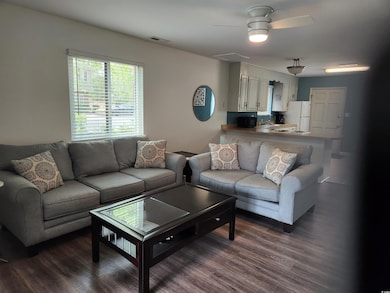 Living area with ceiling fan, visible vents, and d