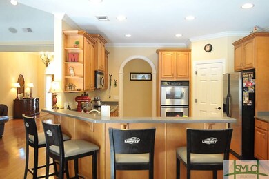 The kitchen features hardwood flooring, large brea