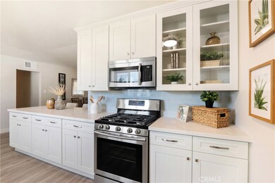 Remodeled kitchen with brand new shaker style cabinets, quartz counters, subway tile backsplash, waterproof vinyl plank flooring and stainless steel appliances.