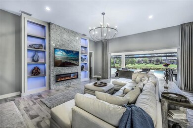 Living area with built in features, a fireplace, wood finished floors, a chandelier, and recessed lighting