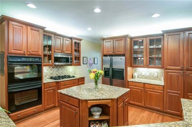 This kitchen has everything you want...abundant granite counter, tile back splash, built-in double ovens, 5-burner gas cook top, an island, 2 bars and under and above cabinet lighting.