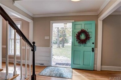 Foyer/entry with coat closet, warm hardwoods and u