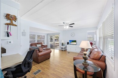 Living room with ceiling fan and light hardwood /