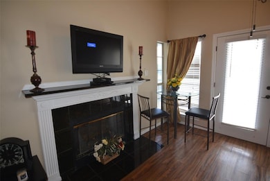 Living area with dark wood-type flooring and a tile fireplace