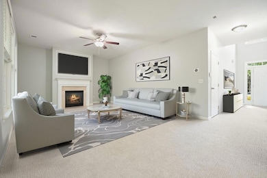 Carpeted living area with ceiling fan and a glass covered fireplace