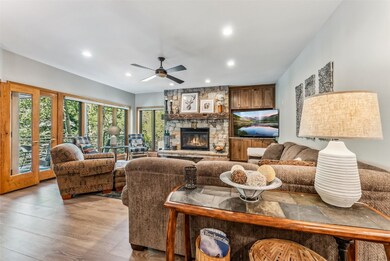 Living room featuring hardwood flooring, a stone f