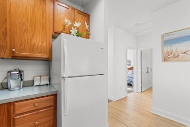 Kitchen featuring white refrigerator and light woo