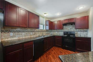Kitchen featuring decorative backsplash, dark hard