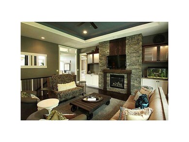 . Stacked stone fireplace and tray ceiling is a ve