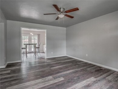 Living room with new flooring, natural light, and 